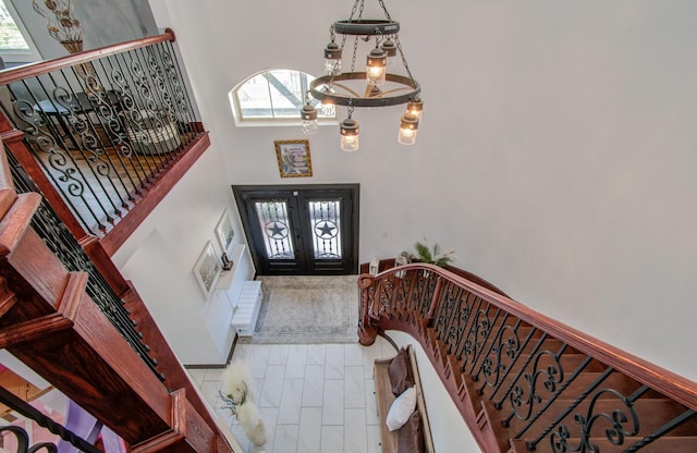 foyer featuring french doors and a towering ceiling