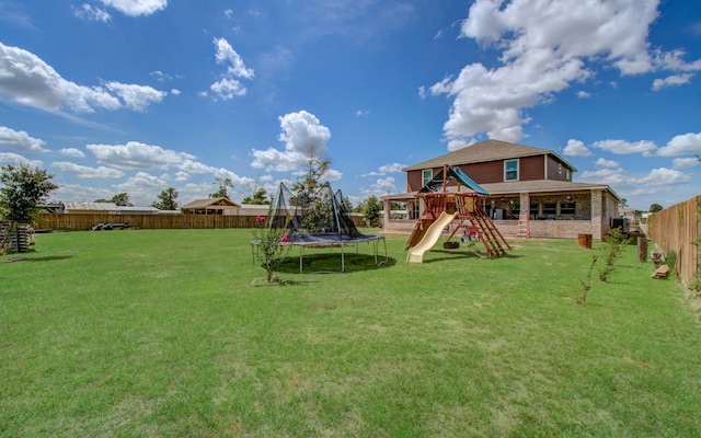 view of jungle gym with a lawn and a trampoline