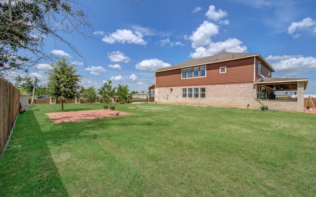 rear view of property featuring a yard and a patio