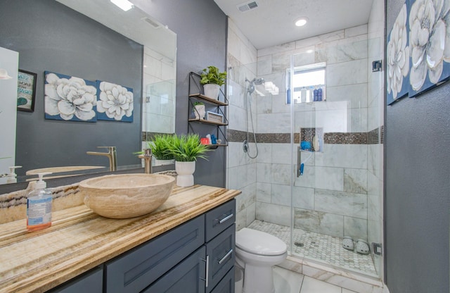 bathroom with tile patterned floors, vanity, an enclosed shower, and toilet