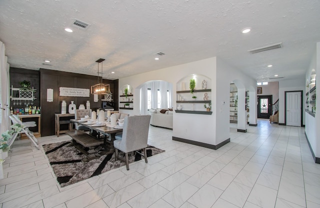 dining space featuring plenty of natural light, a chandelier, and a textured ceiling