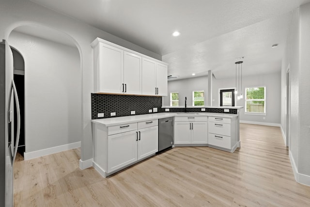 kitchen featuring kitchen peninsula, pendant lighting, stainless steel appliances, and white cabinetry