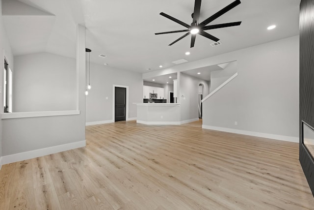 unfurnished living room with ceiling fan, light hardwood / wood-style floors, and lofted ceiling