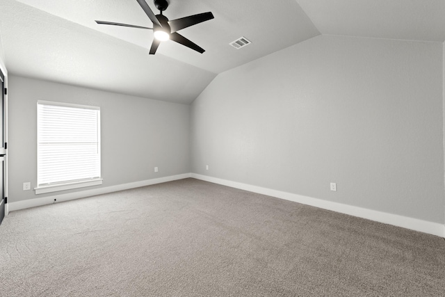 carpeted empty room with ceiling fan and lofted ceiling