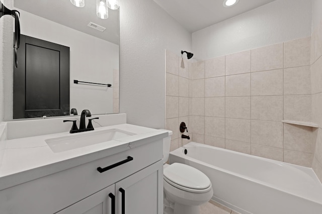 full bathroom featuring vanity, tiled shower / bath combo, and toilet