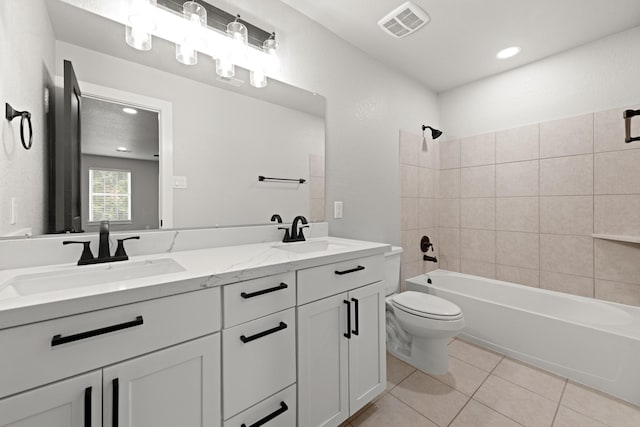 full bathroom featuring tile patterned floors, vanity, toilet, and tiled shower / bath combo