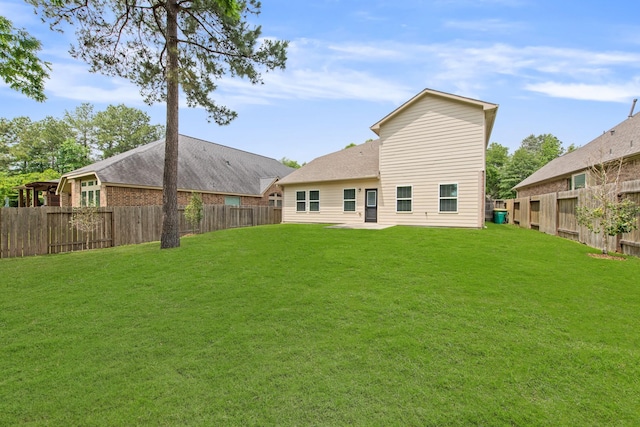 rear view of property featuring a yard