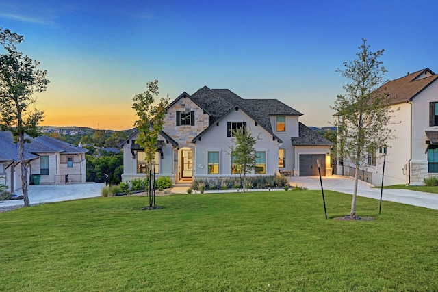 view of front of house featuring a garage and a lawn