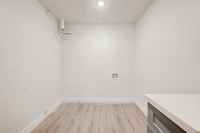 clothes washing area featuring hookup for a washing machine and light wood-type flooring