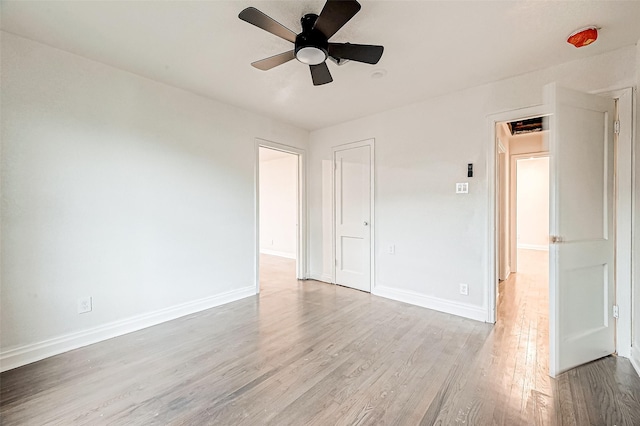 empty room with ceiling fan and light hardwood / wood-style flooring