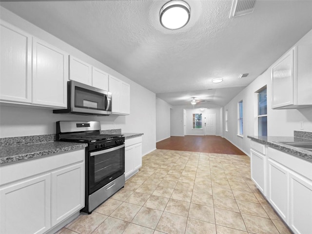 kitchen with white cabinets, light tile patterned floors, and stainless steel appliances