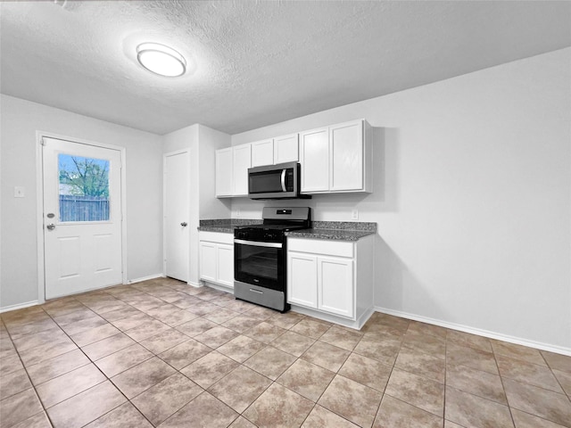 kitchen with light tile patterned floors, white cabinetry, a textured ceiling, and appliances with stainless steel finishes