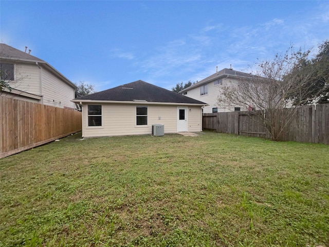 back of house featuring a yard and central AC unit