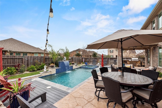 view of swimming pool featuring pool water feature and an in ground hot tub