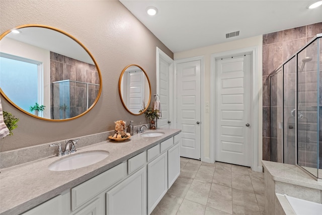 bathroom featuring tile patterned floors, vanity, and a shower with shower door