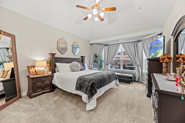 carpeted bedroom with ceiling fan and vaulted ceiling