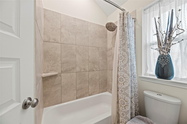 bathroom featuring shower / bath combination with curtain, toilet, and lofted ceiling