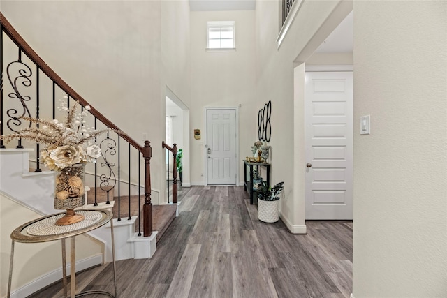 entryway featuring hardwood / wood-style floors and a towering ceiling