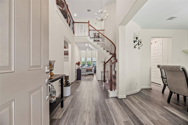 entrance foyer featuring a high ceiling, a notable chandelier, and hardwood / wood-style flooring