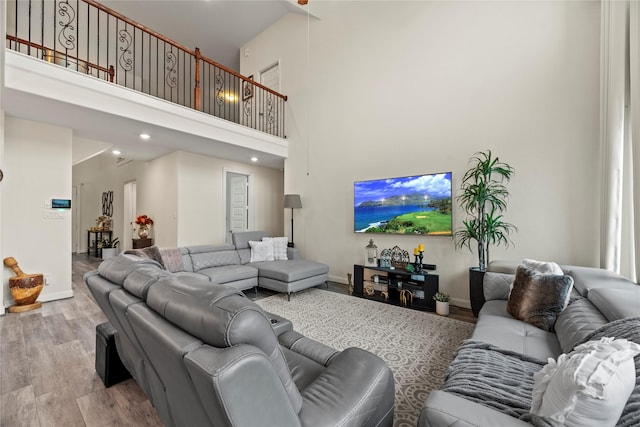 living room with wood-type flooring and a towering ceiling