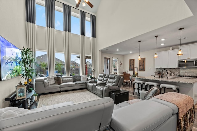 living room with hardwood / wood-style flooring, ceiling fan, a healthy amount of sunlight, and sink