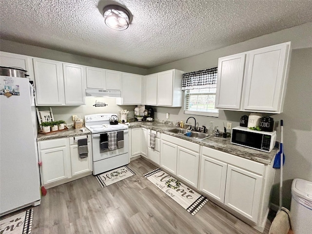 kitchen with white appliances, light hardwood / wood-style floors, white cabinetry, and sink