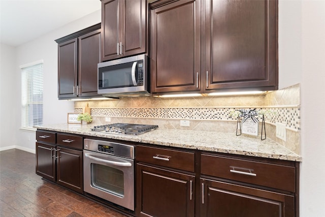 kitchen featuring light stone counters, dark brown cabinets, stainless steel appliances, and dark hardwood / wood-style floors