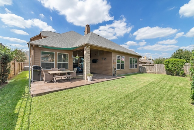 back of house with a patio and a lawn