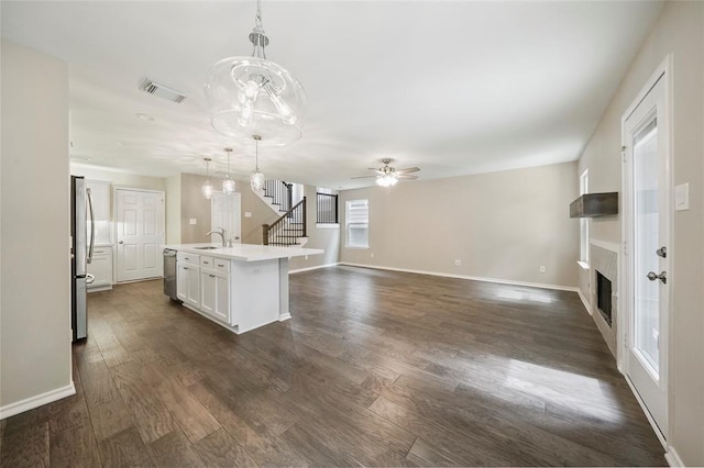 kitchen featuring stainless steel appliances, sink, ceiling fan, an island with sink, and hanging light fixtures