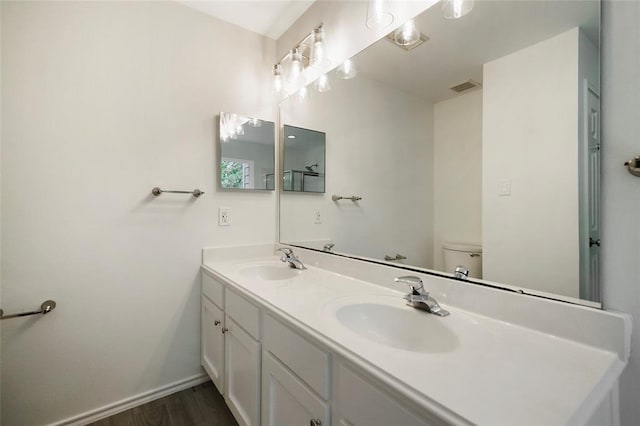 bathroom featuring vanity, hardwood / wood-style flooring, and toilet