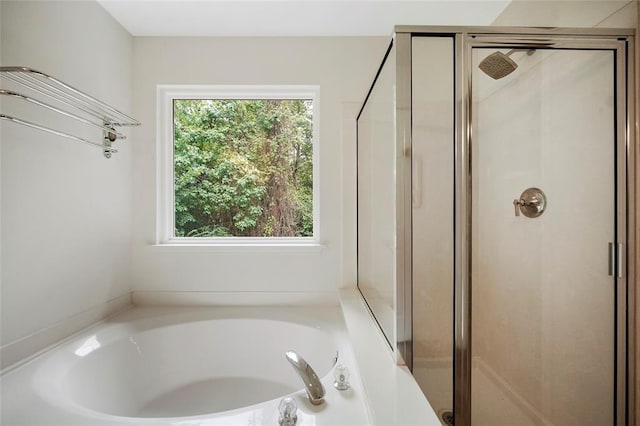 bathroom featuring a wealth of natural light and independent shower and bath