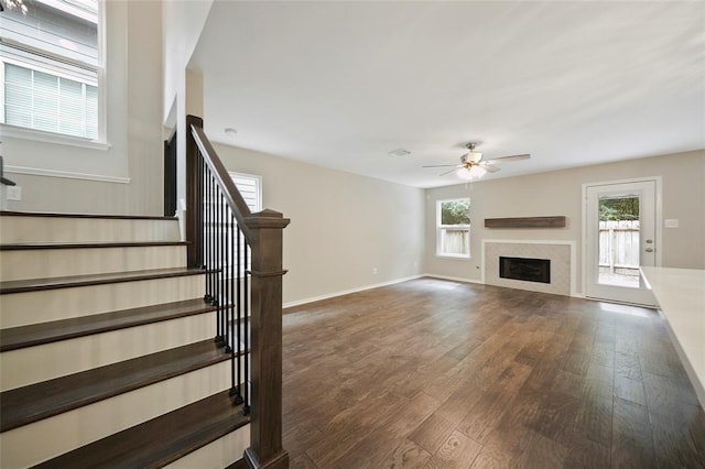 unfurnished living room featuring ceiling fan and dark wood-type flooring