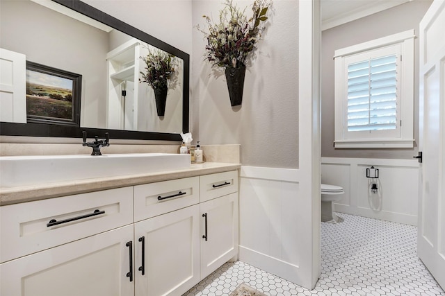 bathroom featuring vanity, crown molding, and toilet