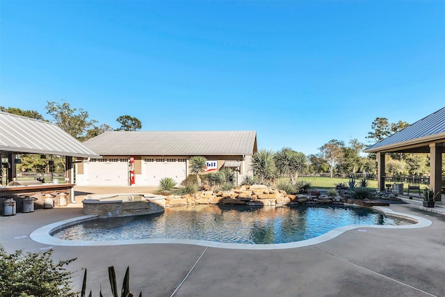 view of swimming pool featuring a patio and an in ground hot tub