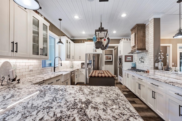 kitchen featuring sink, white cabinetry, hanging light fixtures, stainless steel appliances, and light stone countertops