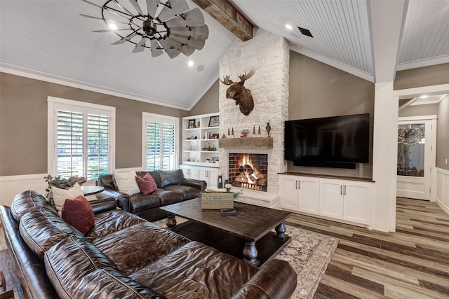 living room with vaulted ceiling with beams, ornamental molding, ceiling fan, a fireplace, and hardwood / wood-style floors