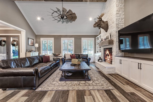 living room with vaulted ceiling, a stone fireplace, built in features, hardwood / wood-style flooring, and wood ceiling