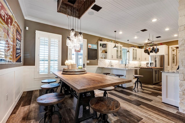 dining space featuring wood ceiling, ornamental molding, dark hardwood / wood-style floors, and sink