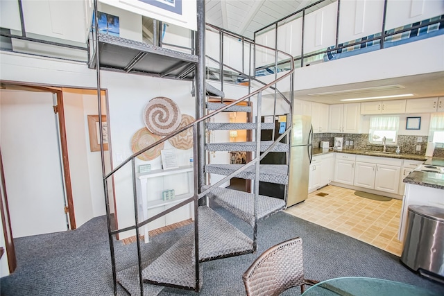 stairs with a high ceiling and sink