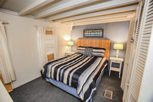 bedroom featuring beam ceiling and dark carpet