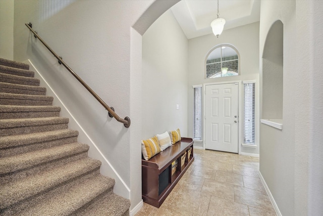 entryway with light tile patterned flooring and a high ceiling