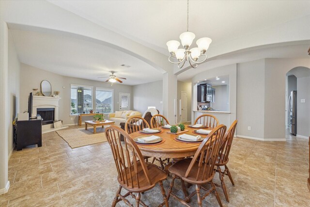 dining area with ceiling fan with notable chandelier