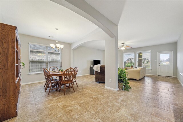 dining area with ceiling fan with notable chandelier