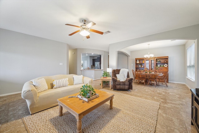 living room featuring ceiling fan with notable chandelier