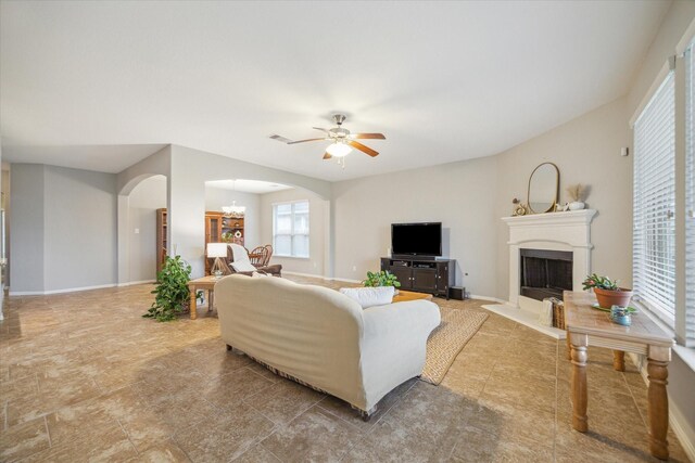 living room with ceiling fan with notable chandelier