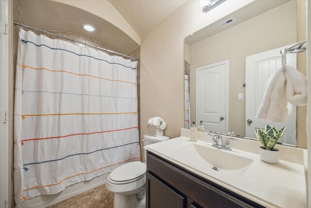 full bathroom with shower / bathtub combination with curtain, tile patterned floors, lofted ceiling, toilet, and vanity