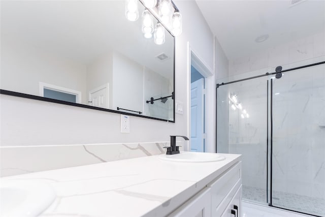 bathroom with vanity and a shower with door