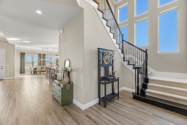 stairway featuring hardwood / wood-style floors and a notable chandelier