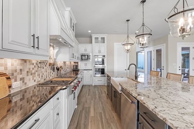 kitchen with appliances with stainless steel finishes, sink, and white cabinets