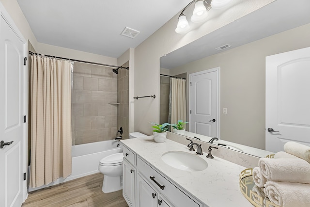 full bathroom with hardwood / wood-style flooring, vanity, shower / tub combo with curtain, and toilet